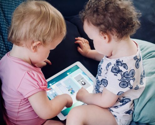 Two young children looking at an iPad