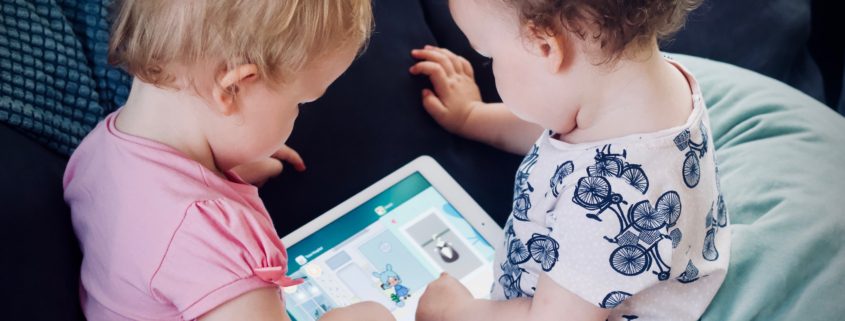 Two young children looking at an iPad