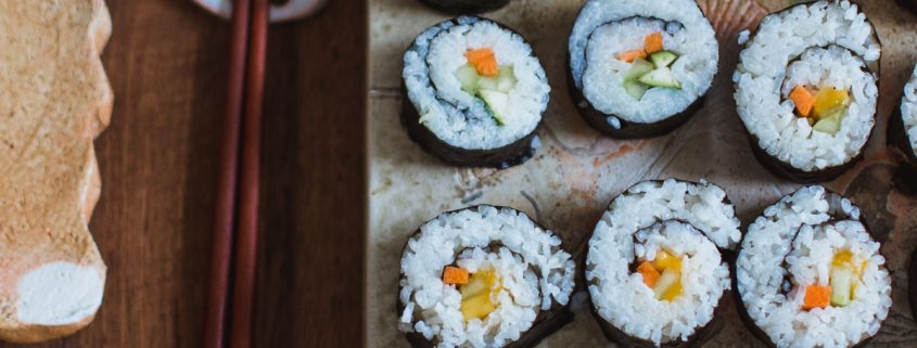 Platter of sushi with chopsticks to the left hand side